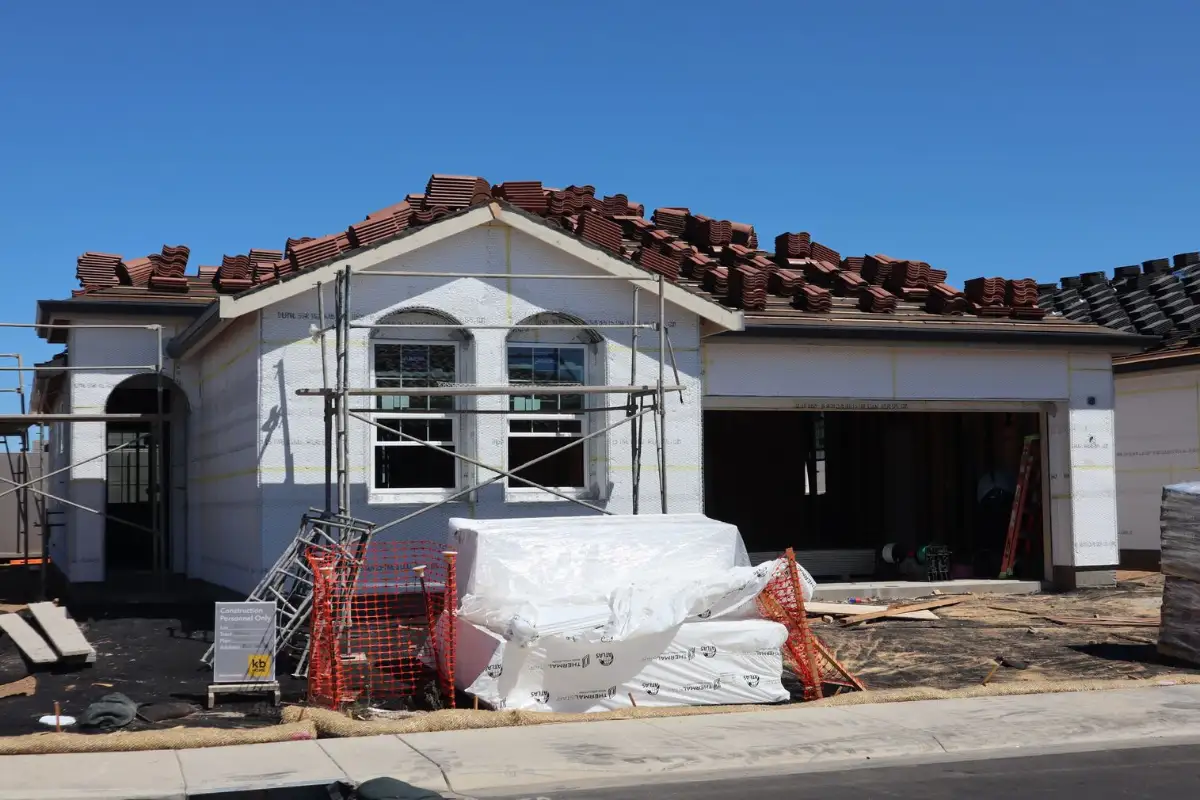Maison en construction inachevée avec matériaux stockés sur le chantier