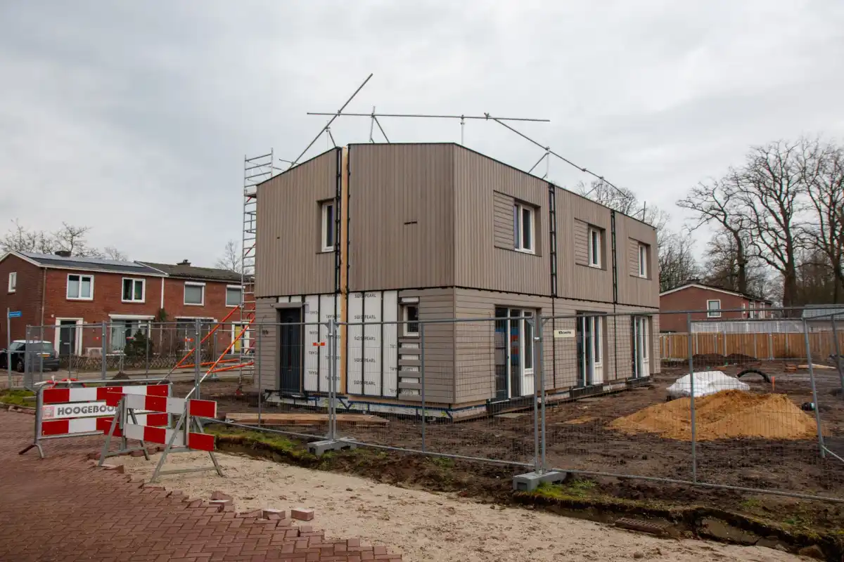Maison individuelle en cours de construction sur un chantier clôturé
