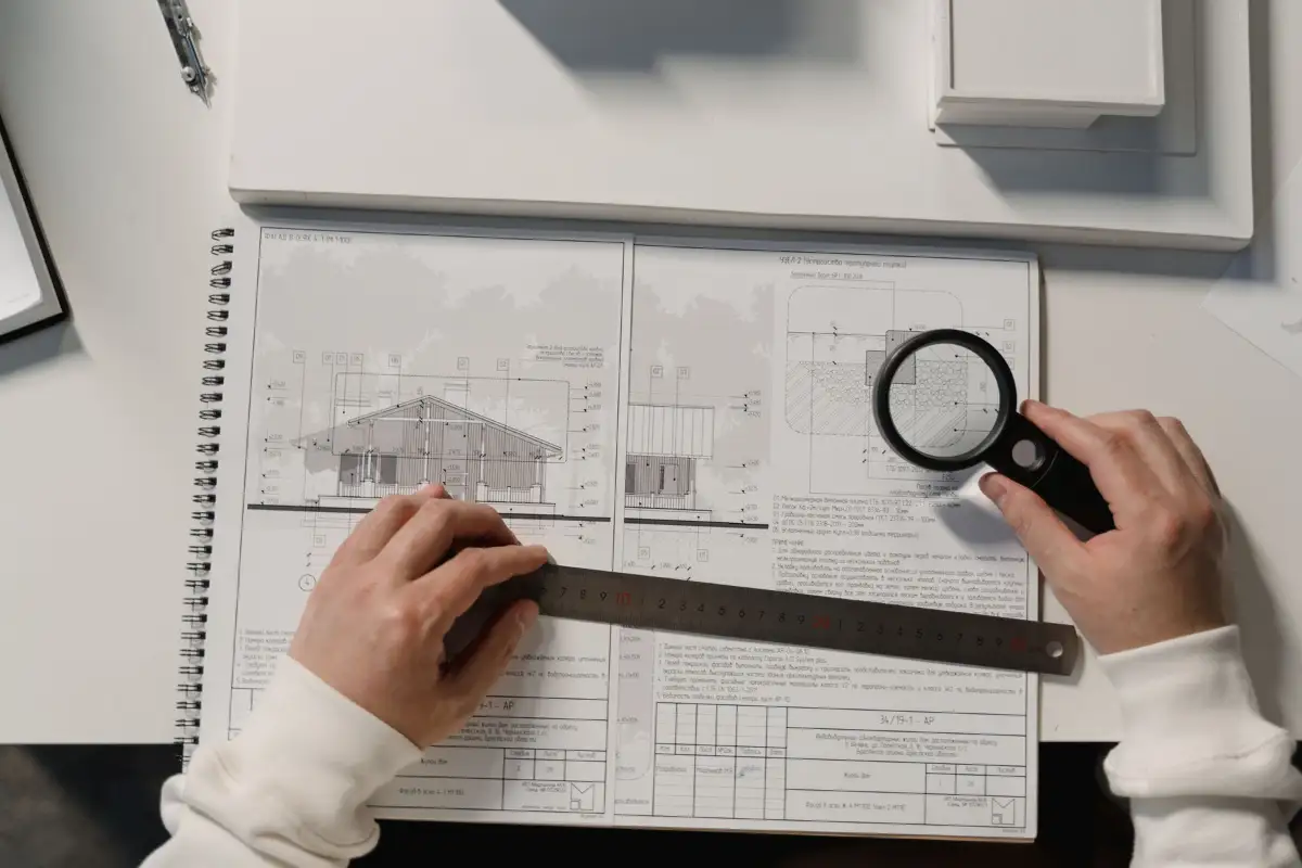 Vérification des plans d’un permis de construire avec une règle et une loupe
