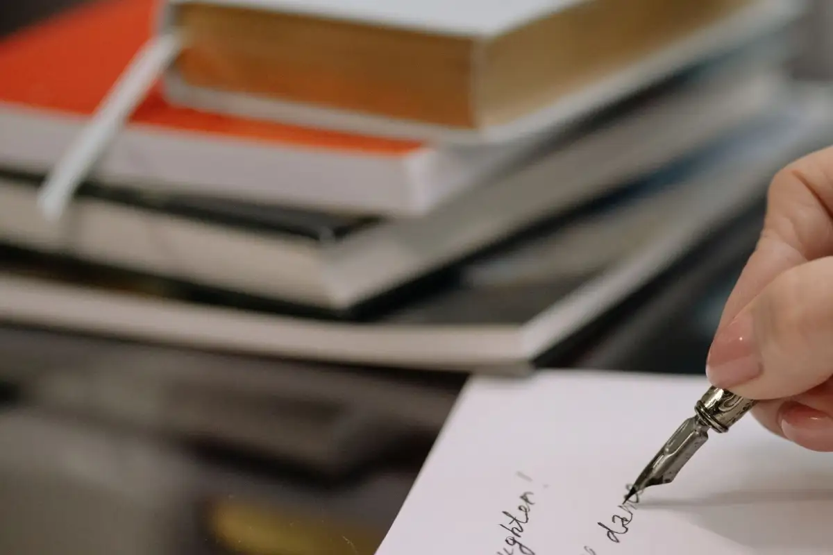 Main écrivant avec un stylo plume, comme pour rédiger un testament