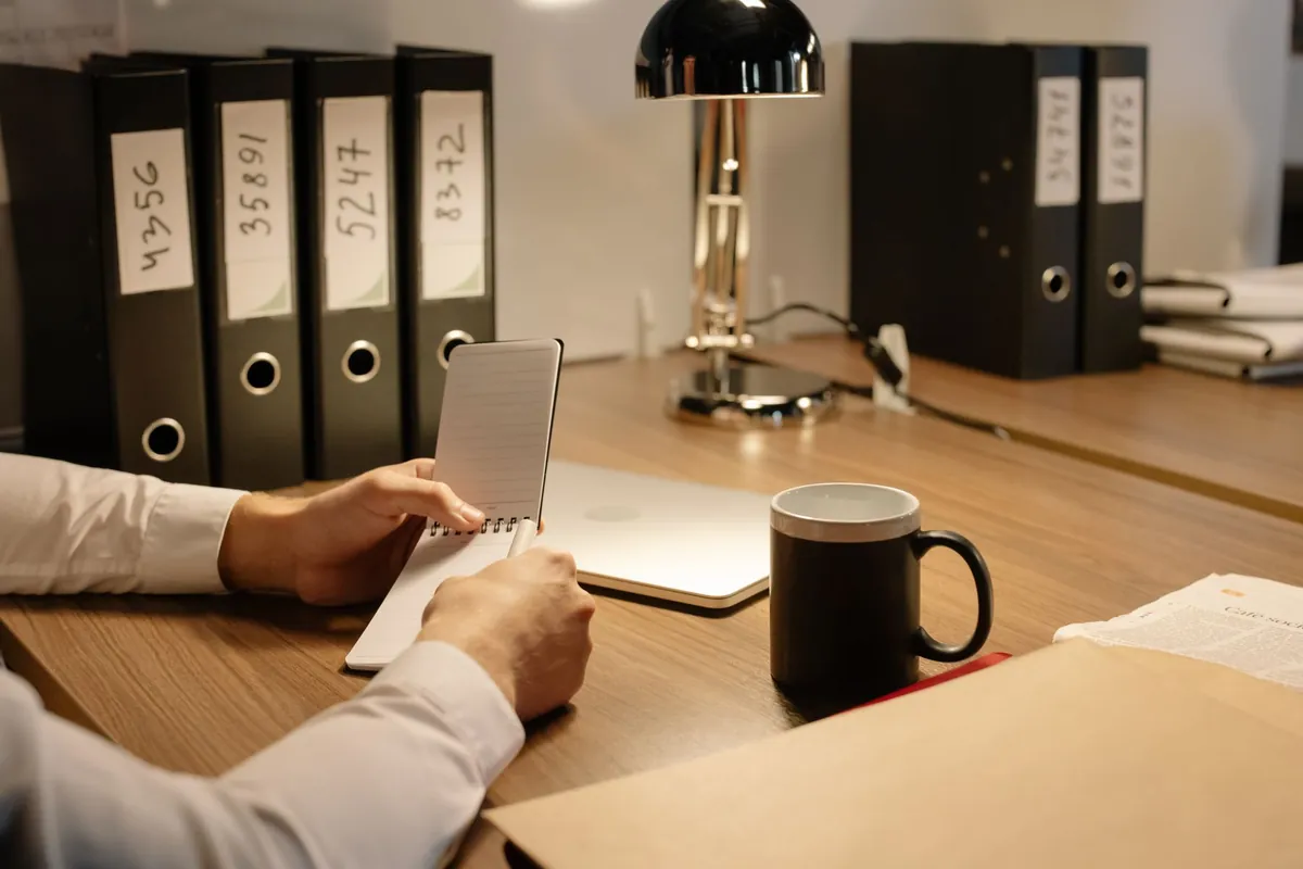 Personne notant une chronologie des faits dans un carnet avant un signalement